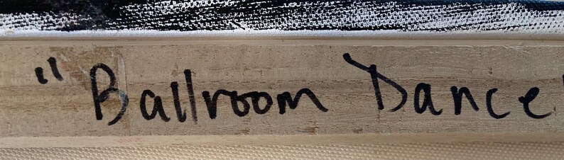 May include: Close-up of a section of a painting with the words "Ballroom Dance" written in black marker on a light-colored wooden frame. The top of the painting has black and white brushstrokes.