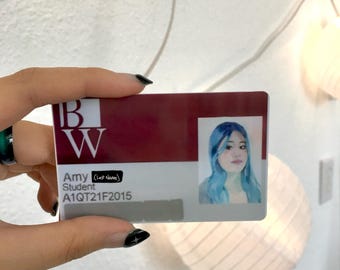 Może przedstawiać: Prostokątna legitymacja studencka z bordowym nagłówkiem i białymi literami BW. Karta zawiera imię Amy, tytuł Student, numer identyfikacyjny A1QT21F2015 oraz portret osoby z niebieskimi włosami umieszczony po prawej stronie dokumentu.