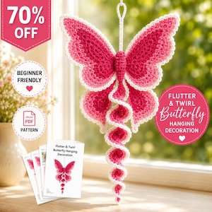 Può includere: Una decorazione a farfalla all'uncinetto realizzata con filati nei toni del rosa e del bianco. La farfalla presenta un corpo centrale, due grandi ali superiori, due ali inferiori più piccole e una lunga coda a spirale.