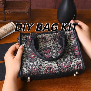 Pode incluir: Um kit de bolsa DIY apresentando uma bolsa estruturada com acabamento em couro preto e corpo em tecido estampado. O tecido exibe um design repetitivo em preto, branco e vermelho. A bolsa inclui duas alças pretas e quatro pequenos pés de metal.