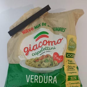 May include: A 500g bag of Giacomo Capelettini Verdura pasta, sealed with a black clip. The packaging features a green and beige design with an image of green pasta on a white plate, text including 'NUEVO MIX DE LEGUMBRES', and nutritional info.