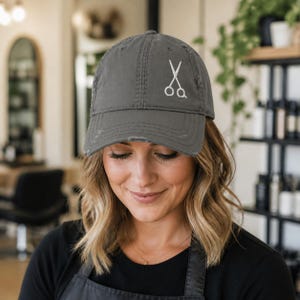 Peut inclure: Une casquette de baseball gris anthracite &agrave; l'aspect us&eacute;, orn&eacute;e d'une ic&ocirc;ne brod&eacute;e blanche repr&eacute;sentant une paire de ciseaux ouverts sur le panneau avant. La casquette pr&eacute;sente une calotte structur&eacute;e, une visi&egrave;re courb&eacute;e effiloch&eacute;e.