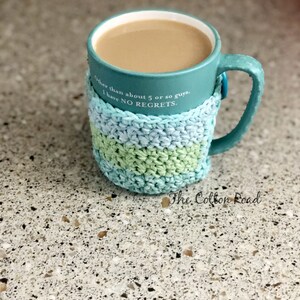 May include: A teal mug with a crocheted cozy in shades of blue and green. The mug has a quote that reads "Other than about 5 or so guys, I have NO REGRETS." The mug is sitting on a speckled countertop.