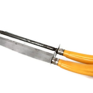 May include: A set of two yellow handled steak knives with a metal blade and a metal sharpening steel.