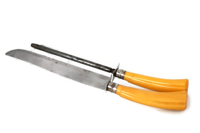 May include: A set of two yellow handled steak knives with a metal blade and a metal sharpening steel.