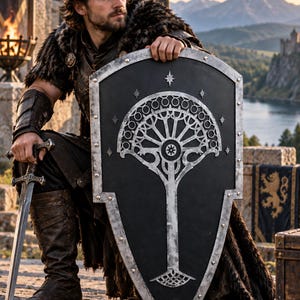 May include: A large, black, kite-shaped shield featuring a silver metallic tree emblem with circular branches and star accents, bordered by silver rivets. The shield is held alongside a silver metal sword with an ornate, dark-toned hilt.
