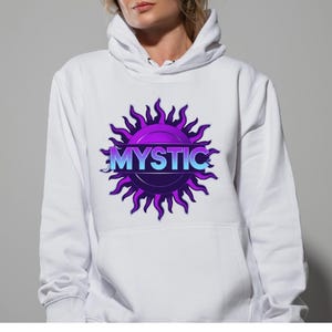 May include: A white hooded sweatshirt featuring a central graphic of a purple sun with wavy rays. The word MYSTIC is printed in a light blue to purple gradient across the center of the sun design. The hoodie includes a front kangaroo pocket.
