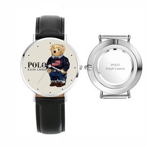 May include: A wristwatch with a black leather strap and a silver-tone case. The cream-colored dial features a graphic of a teddy bear wearing a sweater with an American flag, the text Polo Ralph Lauren, and simple dot hour markers. A separate silver watch case back is shown with the text Polo Ralph Lauren engraved in the center.