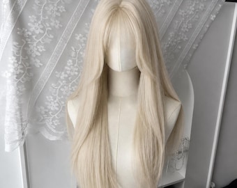 May include: A long, straight, platinum blonde wig featuring a center part and face-framing layers with wispy bangs. The hair is styled in a smooth, sleek texture that falls past the shoulders, displayed on a mannequin head with a neutral tone.