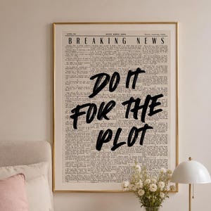 Peut inclure: Une affiche murale encadrée représentant une page de journal vintage intitulée "BREAKING NEWS" avec le texte manuscrit noir et audacieux "DO IT FOR THE PLOT" superposé au centre. Le fond est un papier crème avec des colonnes de petit texte.