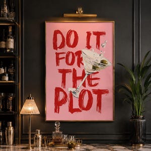 Peut inclure: Une affiche murale rectangulaire sur fond rose clair avec le texte rouge en gras DO IT FOR THE PLOT écrit dans un style coup de pinceau. Un verre à martini avec du liquide éclaboussant et deux olives vertes est placé sur le texte.