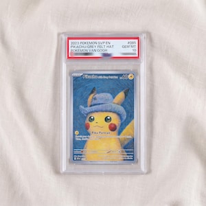 Könnte beinhalten: Eine bewertete 2023 Pokemon SVP EN Pikachu with Grey Felt Hat Sammelkarte in einer durchsichtigen Kunststoffhülle. Die Karte zeigt ein gelbes Pikachu mit blauem Hut vor blauem Hintergrund mit dem Text Pika-Portrait und 60 HP.