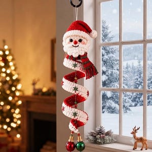 May include: A hanging crochet Santa Claus ornament with a spiral body featuring red and white stripes, green and red accents, and small snowflake details. The ornament ends with two metallic jingle bells in red and green, suspended by a string.