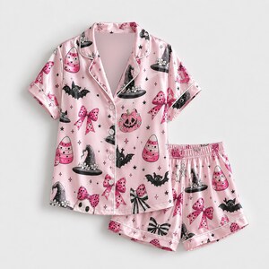 Conjunto de pijama rosa de satén para Halloween con lazos de cinta, murciélagos, sombrero de bruja y estampado de calabazas para una cómoda noche de pijama.