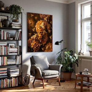 Könnte beinhalten: Ein rechteckiger Wandkunstdruck mit einer detaillierten Nahaufnahme von goldenen Bienenwaben und mehreren Bienen. Das Kunstwerk hängt an einer hellgrauen Wand über einem grauen Polstersessel, der neben einem hohen schwarzen Metallregal steht.