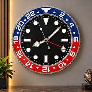 May include: A round wall clock featuring a black face with white circular and rectangular hour markers. The bezel is divided into a blue section with white numbers 2, 4, 6, 8, 10, 12 and a red section with 14, 16, 18, 20, 22.