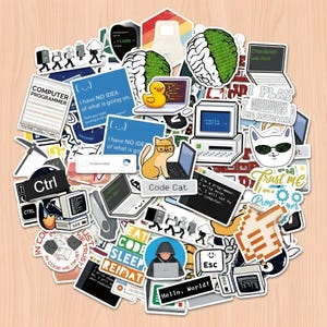 Op de afbeelding: Een verzameling diverse vinylstickers met computerprogrammeerthema's, waaronder pixel art, code-grappen, retrocomputers, katten, eenden en tekst zoals 'I have NO IDEA of what is going on', 'Code Cat' en 'Hello, World'.