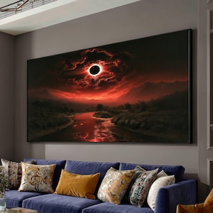 Op de afbeelding: Een rechthoekige wandkunstprint met een donker landschap en een rivier die een dieprode lucht reflecteert. Een zwarte zonsverduistering staat centraal in de wolken boven silhouetten van bergen en bomen in intense tinten.