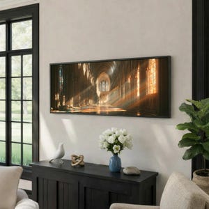 May include: A rectangular wall art print featuring a perspective view of a cathedral interior with tall stone arches, stained glass windows, and golden light rays streaming across the floor, framed in a thin black border and mounted on a wall.
