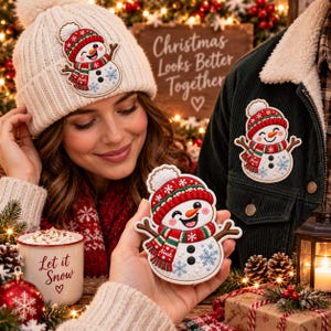 May include: A white knit beanie and a dark green corduroy jacket, both featuring an embroidered snowman patch with a red and green striped scarf labeled Noah, a red hat, and blue snowflake accents, alongside a mug with Let it Snow text.