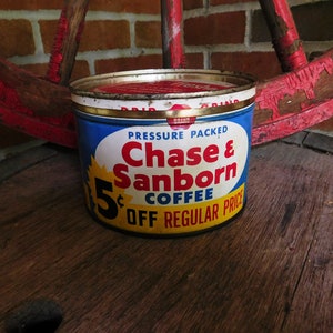 Puede incluir: Una lata vintage de café Chase & Sanborn con una etiqueta azul, amarilla y roja. La etiqueta dice "Pressure Packed Chase & Sanborn Coffee 5¢ Off Regular Price".
