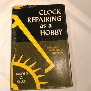 May include: A vintage book titled "Clock Repairing as a Hobby" by Harold C. Kelly. The cover is black and olive green with yellow graphic elements. The text includes "an illustrated how-to guide for the beginner".