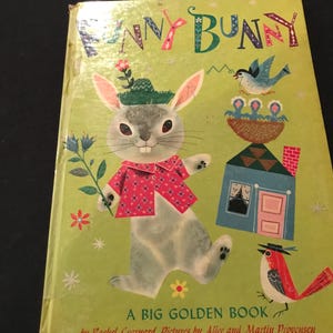 Può includere: Un libro per bambini vintage intitolato "Funny Bunny" con una copertina verde. La copertina presenta un coniglio dei cartoni animati con un cappello e una camicia rossa, che tiene un fiore. Altre illustrazioni includono un uccello, una casa e testo.