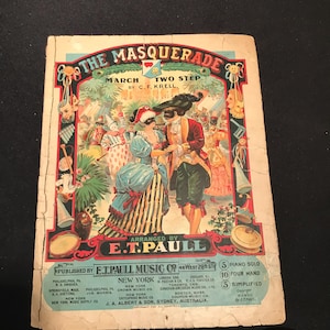 以下が含まれることがあります： 「The Masquerade」のヴィンテージ楽譜カバー。C.F. Krell作曲、E.T. Paull編曲の行進曲とツー・ステップ。仮面舞踏会での仮装した人物のカラフルなイラストが特徴です。E.T. Paull Music Co.より出版。