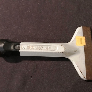 May include: A white and black hand tool with a metal blade. The tool is labeled "DASCO 437 4".