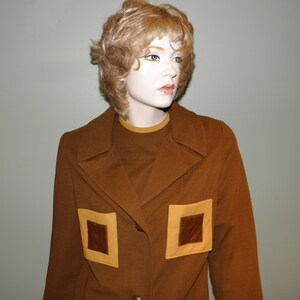 May include: A brown corduroy blazer with two large patch pockets. The pockets have a brown suede insert and a yellow border.