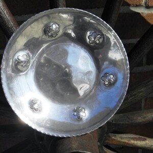 May include: A silver serving dish with a hammered finish and five decorative flower-shaped accents.