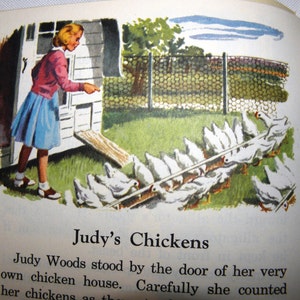 Puede incluir: Una niña con un vestido azul y rojo se para junto a un gallinero blanco, contando una fila de pollos blancos en un patio cercado. El texto "Judy's Chickens" está impreso debajo de la imagen.