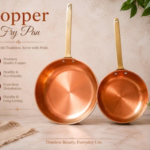 Op de afbeelding: Twee ronde koperen koekenpannen met lange messingkleurige handgrepen en geklonken bevestigingen. De tekst luidt Copper Fry Pan, Cook with Tradition, Serve with Pride, Premium Quality Copper, Healthy & Eco-friendly, Even Heat Distribution, Durable & Long Lasting, Timeless Beauty. Everyday Use.