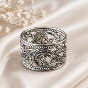 Anello vintage in filigrana d'argento, ampio e vistoso, stile boho, gioiello con decorazioni a volute ossidate.
