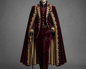 May include: A deep burgundy velvet suit featuring a matching cape with gold leaf embroidery along the edges. The ensemble includes a vest with gold buttons, a gold chain, a black shirt, a burgundy tie, black gloves, and a black cane with a gold handle.