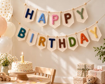 May include: A two-tiered banner featuring off-white fabric pennants strung on a cord, each displaying a single crocheted letter in various colors to spell out Happy Birthday, accented with small wooden beads between each pennant.