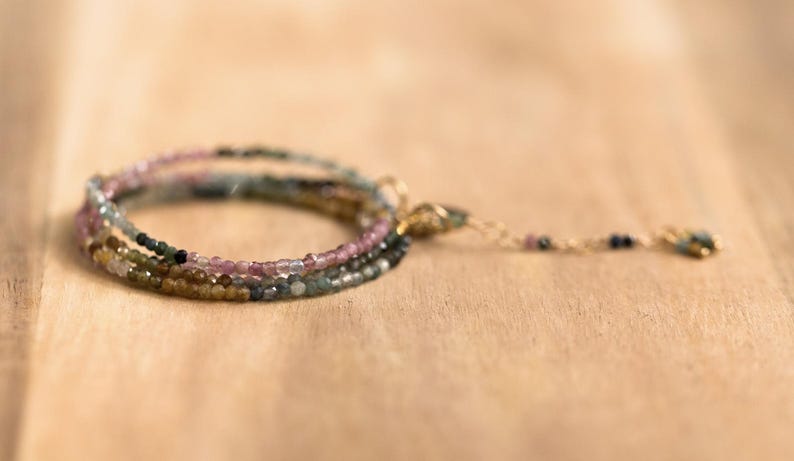 Pu&ograve; includere: Un braccialetto a pi&ugrave; fili con piccole perline colorate nelle tonalit&agrave; del rosa, verde e oro. Il braccialetto ha una delicata catena e chiusura dorata. Le perline sono infilate per creare un effetto a strati, perfetto per l'uso quotidiano.