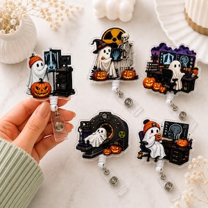 May include: Five acrylic badge reels featuring ghost characters in medical settings with pumpkins. One ghost examines an X-ray, another holds a hand X-ray with a skeleton, one sits at a computer, one lies in an MRI machine, and one drinks from a mug.