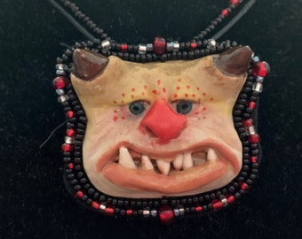 ONS10-BEADED OGRE NECKLACE - This unique necklace is an original, one of a kind, hand sculpted necklace, made of stoneware clay and beads.