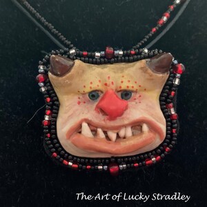 ONS10-BEADED OGRE NECKLACE - This unique necklace is an original, one of a kind, hand sculpted necklace, made of stoneware clay and beads.