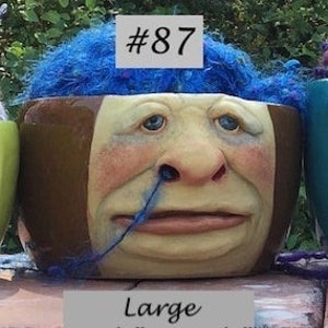Puede incluir: Cuatro cuencos de lana de cerámica de diferentes tamaños, con caras caprichosas y lana que se derrama por la parte superior. Los cuencos están etiquetados con el número #86, #87, #88 y #89. Los cuencos están etiquetados con su tamaño: Regular 3 1/4" x 6 1/4", Large 3 3/4" x 6 3/4", XL 4 1/4" x 7 1/2", y XXL 4 3/4" x 8".