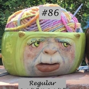 Puede incluir: Cuatro cuencos de lana de cerámica de diferentes tamaños, cada uno con una cara única y lana que se derrama. Los cuencos están etiquetados con números y tamaños, incluyendo "Regular 3 1/4" X 6 1/4"", "Large 3 3/4" X 6 3/4"", "XL 4 1/4" X 7 1/2"" y "XXL 4 3/4" X 8"".
