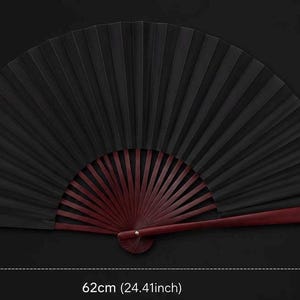 May include: A black folding hand fan with dark red wooden ribs. The fan measures 13 inches in height and 24.41 inches in width when fully opened. The text 33cm (13inch) and 62cm (24.41inch) is visible on the image indicating the dimensions.