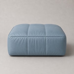 May include: A low, rectangular ottoman upholstered in smooth, matte light blue leather. The surface features a grid of stitched seams creating six distinct, padded square sections across the top and front face of the furniture piece.