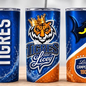 Puede incluir: Tres vasos de acero inoxidable con tapas y pajitas, con un diseño en azul y naranja. Incluye un tigre con corona, los textos TIGRES DESDE 1907, TIGRES DEL LICEY y LICEY CAMPEONES 1907, junto con gráficos de salpicaduras de agua en el fondo.