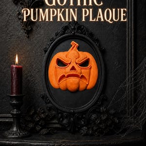 May include: An orange pumpkin plaque with a carved, angry facial expression mounted inside a black oval frame. The text GOTHIC PUMPKIN PLAQUE is displayed in light-colored lettering above the frame, which is set against a dark, textured wall.