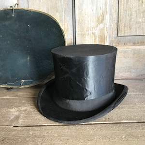 May include: A black top hat with a wide brim and a smooth, shiny finish. The hat is made of a sturdy material and has a classic design.