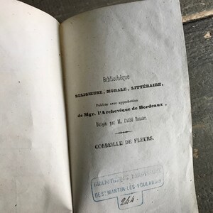 May include: A vintage book titled "Corbeille de Fleurs" from the "Biblioth&egrave;que Religieuse, Morale, Litt&eacute;raire" series. The book was published with the approval of the Archbishop of Bordeaux and directed by M. l'abb&eacute; Rouzier.
