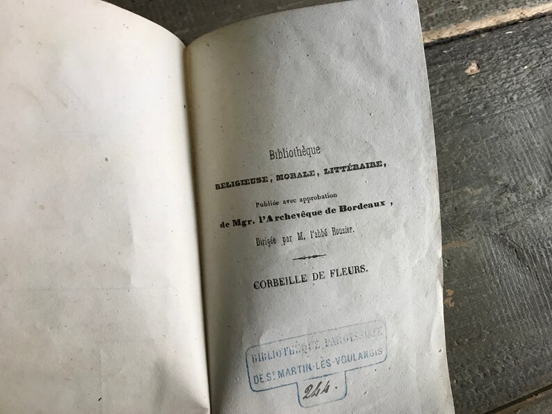 May include: A vintage book titled "Corbeille de Fleurs" from the "Biblioth&egrave;que Religieuse, Morale, Litt&eacute;raire" series. The book was published with the approval of the Archbishop of Bordeaux and directed by M. l'abb&eacute; Rouzier.