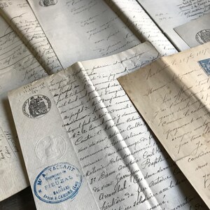 May include: A collection of antique documents, featuring handwritten script and official seals. The papers are aged with visible wear, showcasing historical text and stamps. The image evokes a sense of history and vintage ephemera.